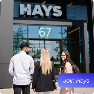 3 Mitarbeitende laufen auf den Haupteingang von Hays zu