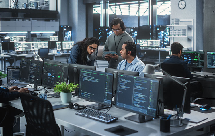 Eine Gruppe von drei Software Engineers besprechen ein Thema in einem IT-Office